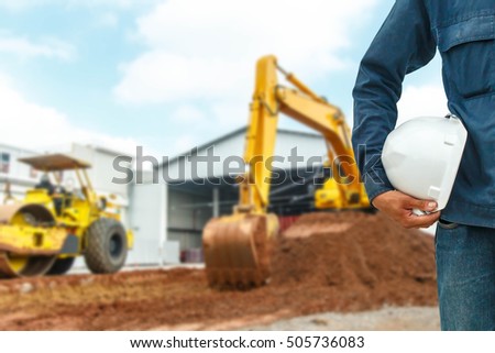 The engineering and safety helmets stood on the details of Closeup skid steer loader excavator at road construction work