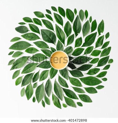 Coffee or tea cup on green leaves background Flat lay.