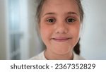 Small photo of serious little girl portrait. happy family a problems kid dream concept. sad frowning little girl close-up indoors. lifestyle depression unhappy child. lonely frightened daughter portrait