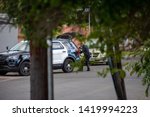 Small photo of Northridge, CA / United States - May 27, 2019: LAPD Patrol Units respond to brandishing/ADW call in suburban neighborhood with less lethal device. A LAPD officer is shown here removing the device.