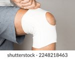 Small photo of Man wearing an elastic ace bandage on his knee