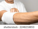 Small photo of Man wearing an elastic ace bandage on his elbow
