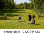 Small photo of Golfers walks along the golf course during training. Sports of millionaires, general view of the golf course and flight golfers go with equipment