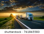 Overtaking trucks on an asphalt road in a rural landscape at sunset