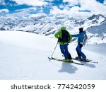 Winter extreme sport. A hiking trip on skis. Two skiers admire beautiful alpine landscapes. 