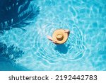 Top view of beautiful woman earing sunhat relaxing in swimming pool