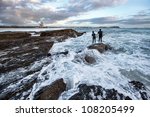 Surfers catching a wave from rocks, Elephant Rock, Currumbin beach, Gold Coast, Australia