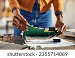 Small photo of Employee black woman hands working on stacks of workpaper files and searching for unfinished documents. African american secretary holding and arranging stack of business documents and folders.