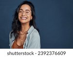 Small photo of Casual young multiethnic woman with eyeglasses smiling at camera on blue background. Close up face of happy mixed race girl laughing with eyeglasses isolated with copy space. Beautiful girl laughing.