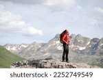 Hiker in red breathing fresh air in the top of a mountain