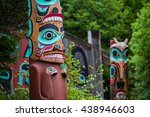 Detail of totem pole at Saxman Village tribal house near Ketchikan Alaska with Sun Raven in background