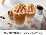 Iced caramel latte topped with whipped cream and caramel sauce, refreshing and sweet coffee drink