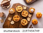Small photo of Halloween pumpkin pies with carved pumpkin or Jack-o-lantern face on top
