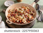 Small photo of Corned beef hash with potatoes, cabbage and carrot in a cast iron pan