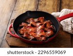 Cooked bacon in a cast iron pan, ready to eat breakfast staple