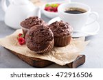 Chocolate muffins with a cup of coffee and fresh berries on the table
