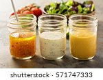 Variety of homemade sauces and salad dressings in mason jars including vinaigrette, ranch and honey mustard