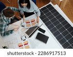 Small photo of Green energy engineer helping client to figure out how many solar panels she needs for her house