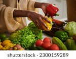 Woman taking red and yellow bell peppers for recipe