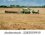 Small photo of combines with unhooked cutter in the form of a trailer, transports after harvesting, on the background of stubble, mode of moving
