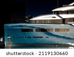 Background urban photo of a modern luxurious super yacht anchored in a big city port at sunset