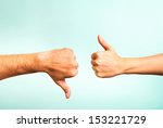 Two hands signalling thumbs up and thumbs down. The smooth hand on the left is making a thumbs up gesture while the hairy hand on the right is making a thumbs down gesture.