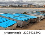 Small photo of Fishing boats ashore on the Ben Buckler Point area facing North Bondi Beach backgrounded by The Playground, the beachfront buildings at Campbell Parade and the Life Saving Club. Sydney-NSW-Australia.