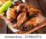 barbecue chicken wings close up on wooden tray shot with selective focus