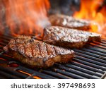 grilling steaks on flaming grill and shot with selective focus