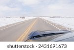 Small photo of Navigating a frontage road post-winter storm offers a serene drive. The surrounding landscape, blanketed in snow, contributes to the peaceful and picturesque environment, enhancing the driving
