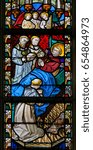 Small photo of GHENT, BELGIUM - DECEMBER 23, 2016: Stained Glass window depicting praying monks next to the deathbed of a Christian Saint in the Cathedral of Saint Bavo in Ghent, Belgium.