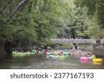 Small photo of Helen, GA USA - September 9, 2023: Telephoto shot shows people tubing on the Chattahoochee River on a hot summer day on September 9, 2023 in Helen, GA.