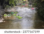 Small photo of Helen, GA USA - September 9, 2023: High-angle view shows people tubing on the Chattahoochee River on a hot summer day on September 9, 2023 in Helen, GA.