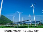 Small photo of White wind turbine. Subaltern's mountains and sky in the background.