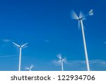 Small photo of White wind turbine. Subaltern's mountains and sky in the background.