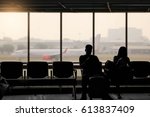 silhouette of man and woman waiting for flight in the passenger lounge
