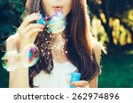 Girl blowing bubbles outdoor. Focus on lips.