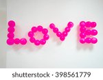 Pink balloons form the word of love