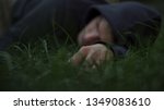 Small photo of Victim of thugs lying on grass, mans corpse, murdered citizen, crime scene