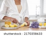 young woman cutting lemon on... | Shutterstock . vector #2170358633