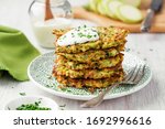 Zucchini fritters, vegetarian zucchini pancakes, served with fresh herbs and sour cream.
