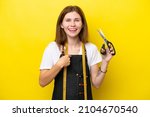 Young seamstress English woman isolated on yellow background with surprise facial expression