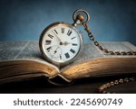 Small photo of The clock lies on an old book. Clock as a symbol of time, the book is a symbol of knowledge, science. Concept on the topic of history, science, memory, information. Vintage watch, clock background.