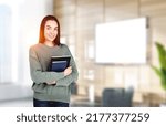 Small photo of Attractive businesswoman wearing casual wear is standing holding notebook at office workplace in background. Concept of working process, taking notes for daily schedule, scorekeeper and secretary