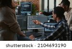 Small photo of Software developers discussing about source code compiling discovers errors and asks the rest of the team for explanations in front of multiple screens running algorithms. Programmers doing teamwork.