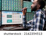Busy financial analyst sitting at workstation while reviewing investment fund data and real time statistics. Attentive forex stock market trader being mindful while analyzing buy and sell values.