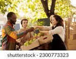 Vendor offering samples to customers while selling home-grown fruits and vegetables at local farmers market. Young multiracial family couple tasting natural organic produce while visiting food fair