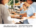 Small photo of Image showcasing charity workers at outdoor food bank, serving the needy homeless people, providing support and alleviating hunger. Volunteers distributing meal rations to poor individuals.