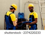 Small photo of Certified engineers asked to do air conditioner check, refilling refrigerant. Teamworking colleagues using manifold gauges to properly calibrate the pressure in HVAC system