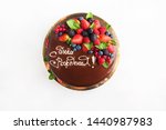 Cake with fruit, chocolate, flowers is isolated on a white background close-up and copy space. In Russian the inscription 